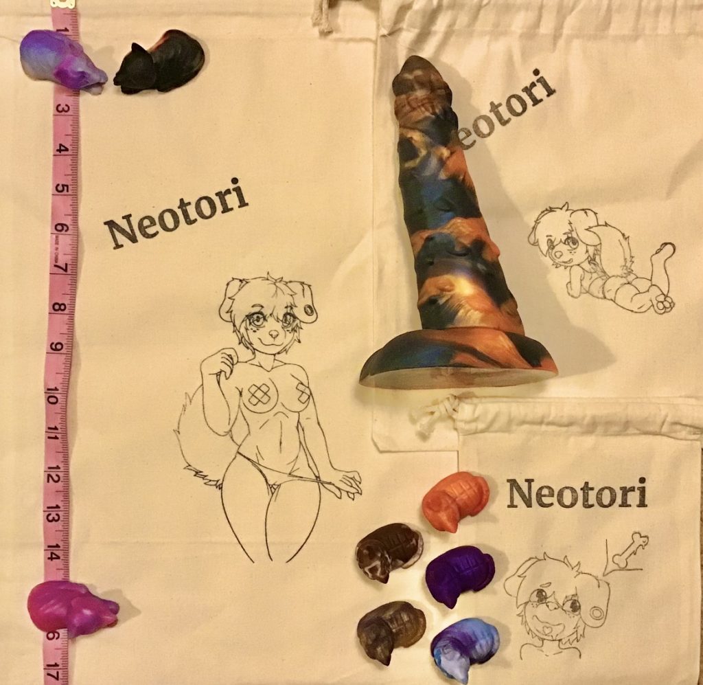 Three bags of different sizes: Small, medium, and large. The large is over 17" long. Each bag features different pinups of Neotori's canine character Lina: Lounging and looking back over her shoulder; just her head, with a thought bubble thinking about bones; and a full frontal view, pulling her panties off with stickers covering her nipples.