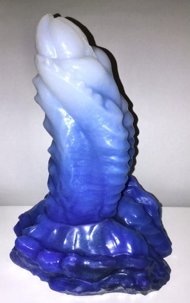 A stout, highly textured alien dick with ridges and pricks. The base is made of hefty scales. It's a fade of deep blue at the base to white at the tip.